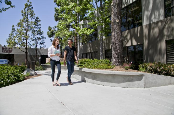 two students walking down sidewalk at Bastyr San Diego campus
