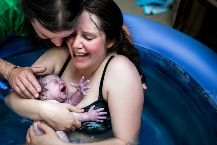 mom in a birth tub with her newborn