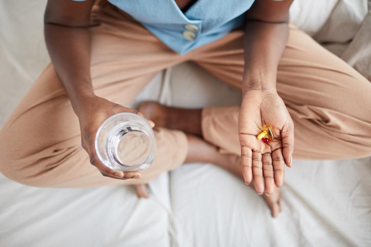 high angle close up of person holding pills and vitamins in hand