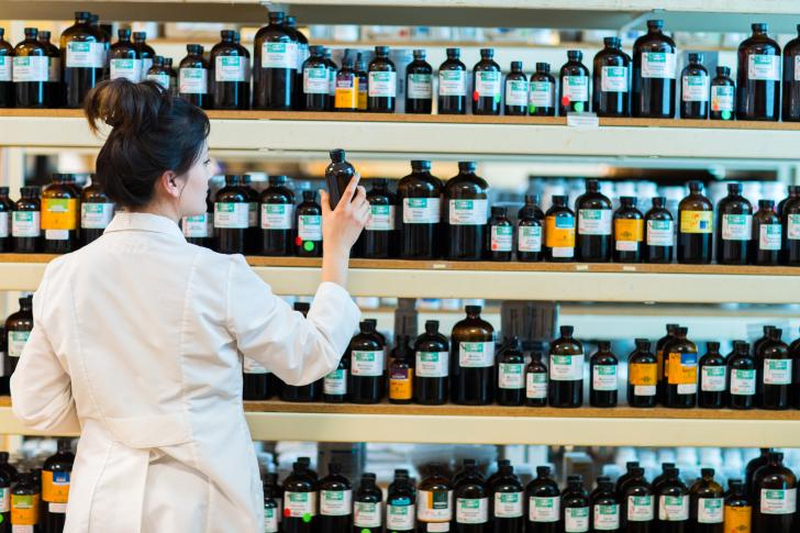 clinician looking at medicine on dispensary shelves