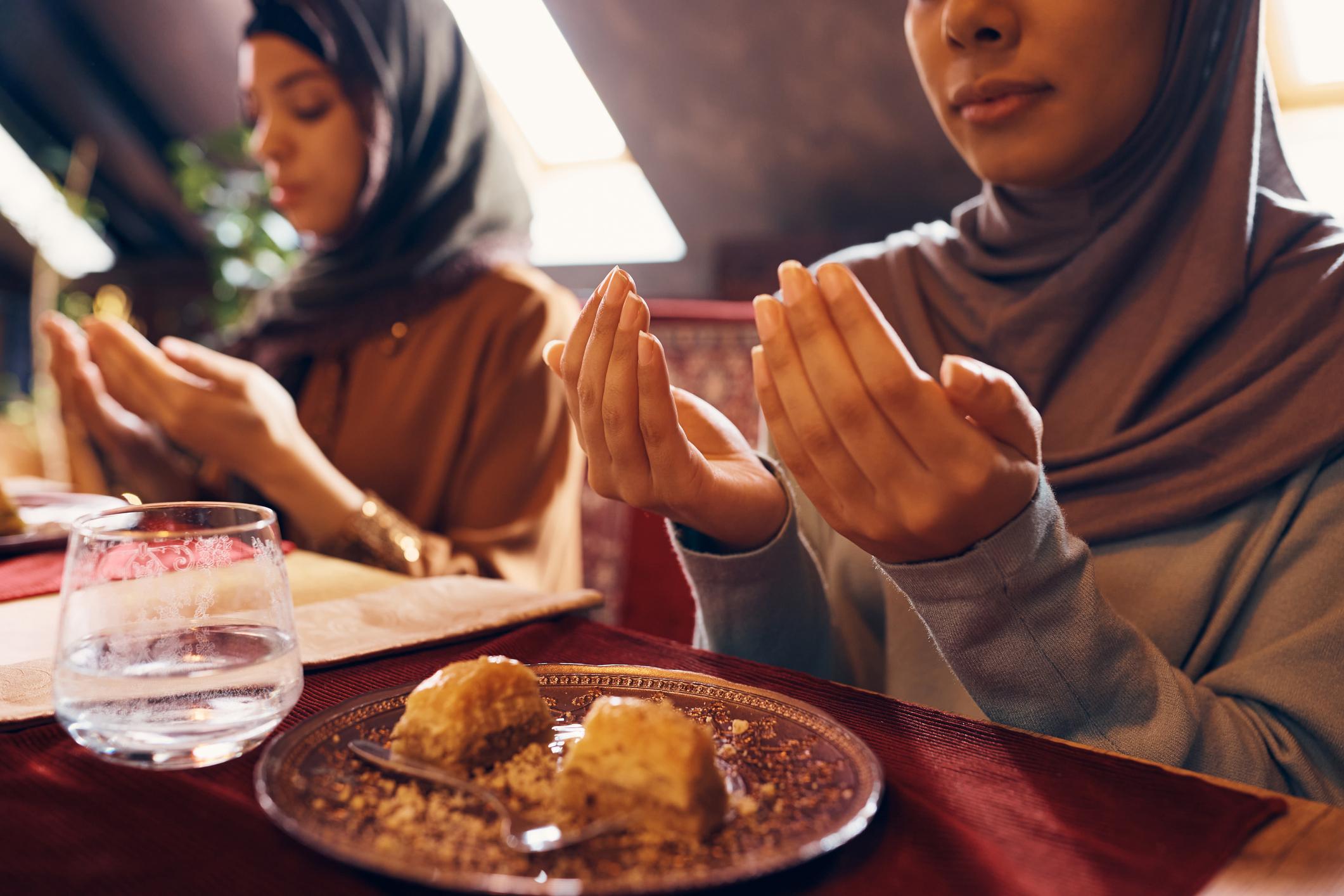 Close-up of Muslim woman starting the fast with dua at Suhoor during Ramadan