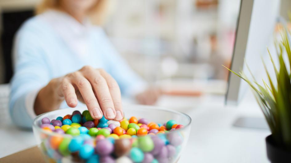 person reaching for bowl of jellybeans