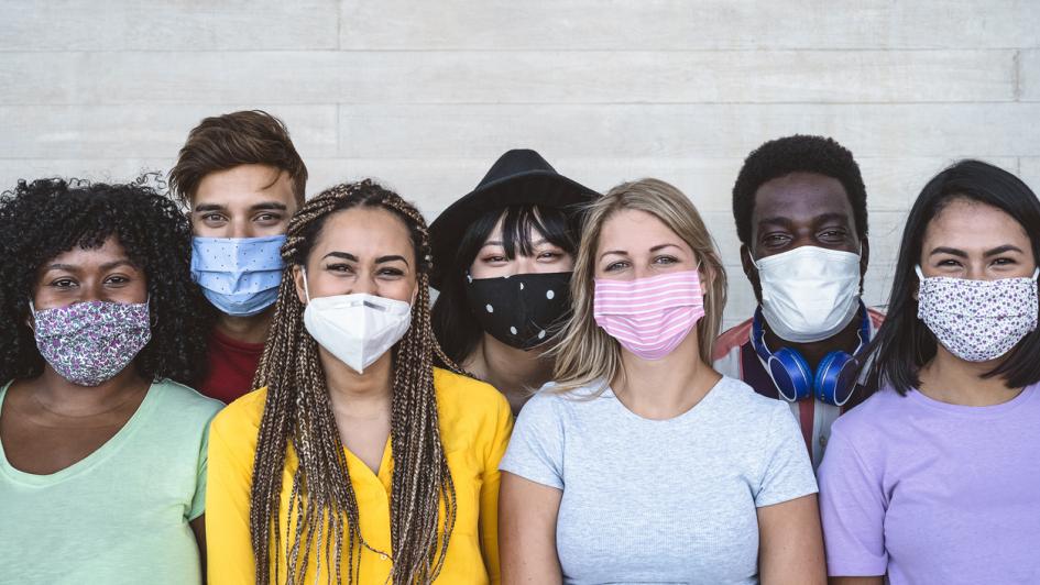 seven people with surgical masks on posing for photo